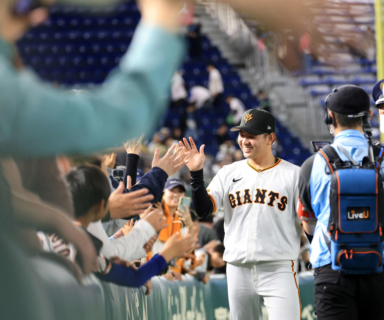 巨人対ヤクルト　プロ初勝利を挙げた巨人石川は笑顔でファンとハイタッチ（撮影・浅見桂子）