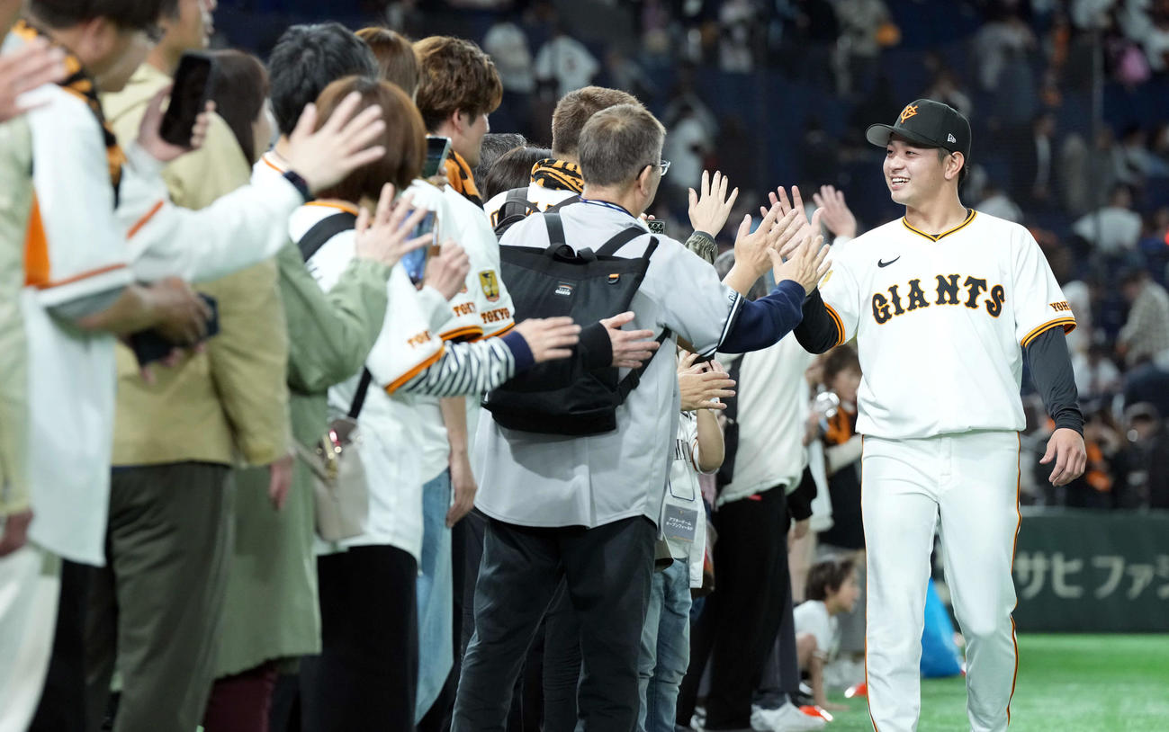 巨人対ヤクルト　プロ初勝利を挙げた巨人石川は、ファンとハイタッチを交わす（撮影・たえ見朱実）