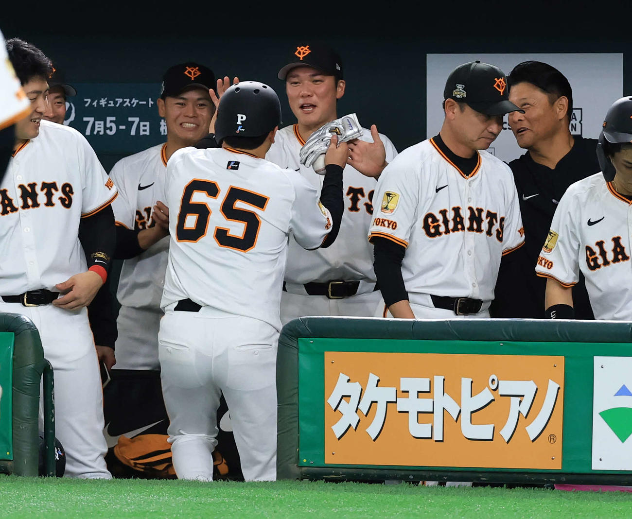 巨人対ヤクルト　2回裏巨人の攻撃終了後、先制適時打の石川〔手前）を笑顔で迎える坂本（奥）ら（撮影・浅見桂子）