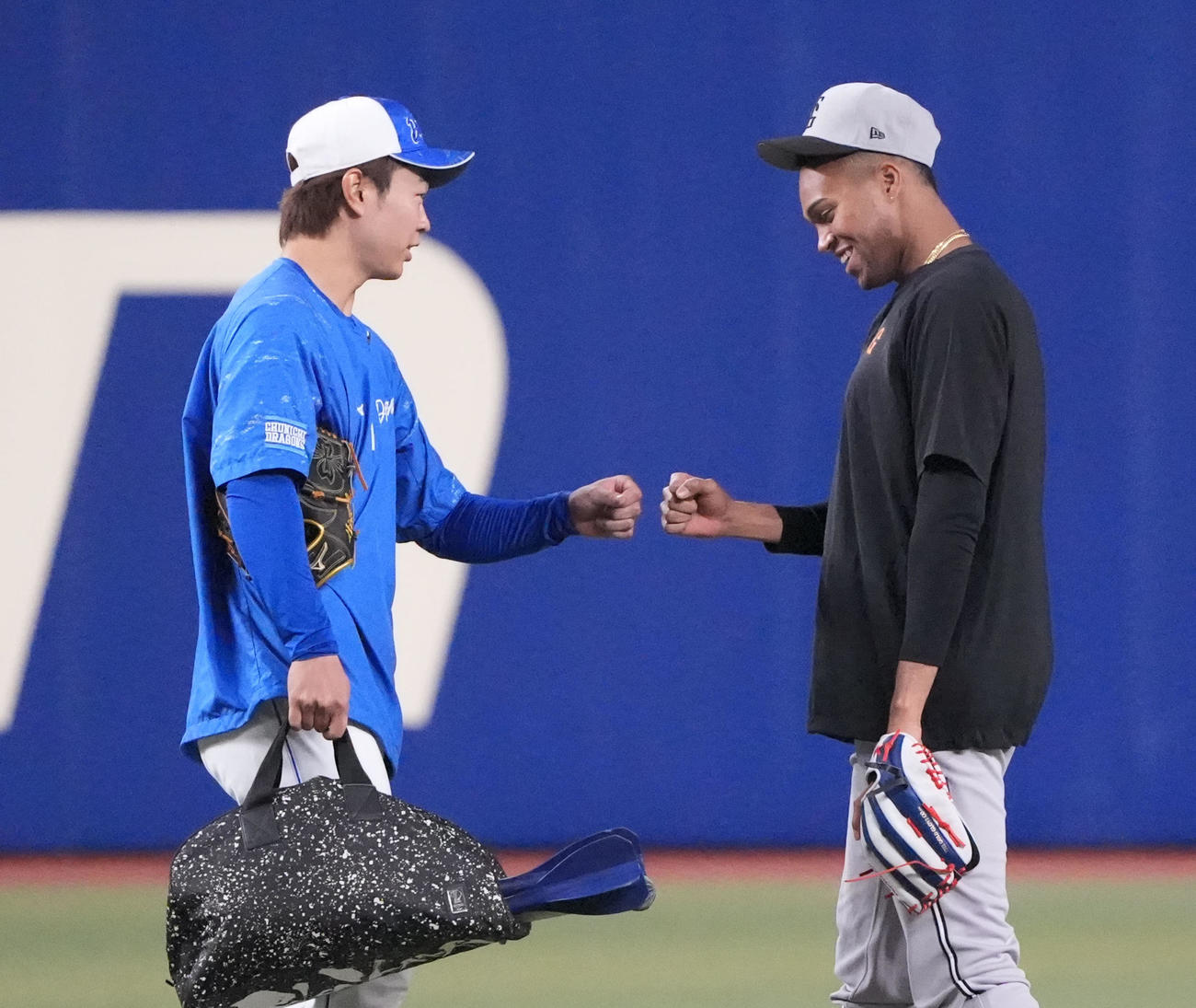 中日対巨人　試合前、高橋宏とタッチを交わすマルティネス（右）（撮影・森本幸一）