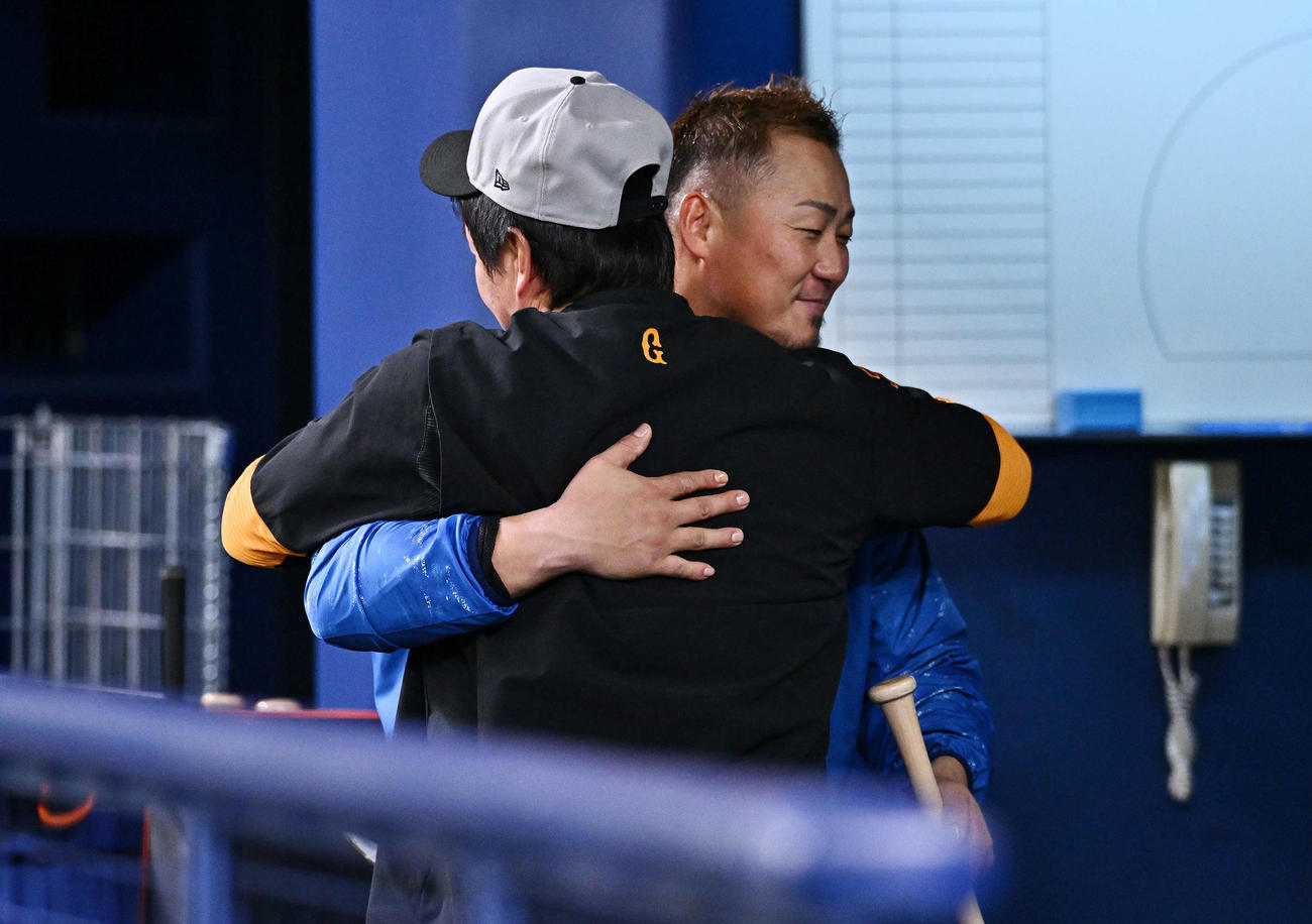 中日対巨人　試合前練習でハグする中日中田（後方）と巨人長野（撮影・滝沢徹郎）