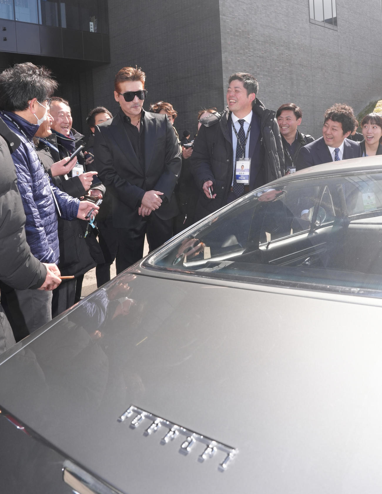 フェラーリで球場入りした日本ハム新庄監督（中央）は車を紹介する（撮影・足立雅史）