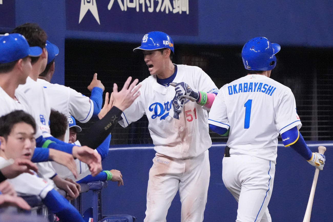 中日対巨人　7回裏中日無死一、三塁、木下のスクイズで生還しナインとタッチを交わす上林（中央）（撮影・森本幸一）