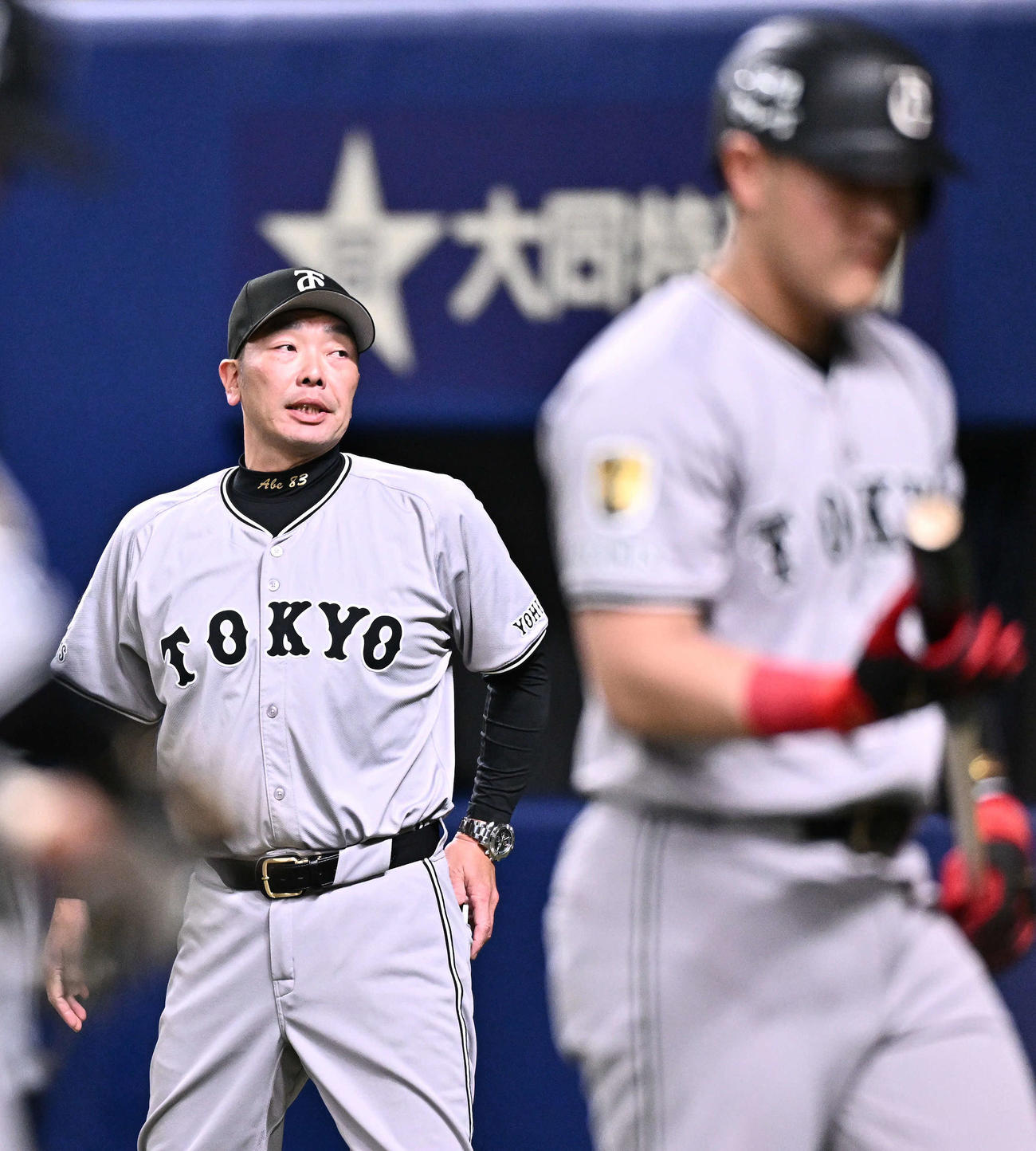 中日対巨人　8回表、空振り三振に倒れ引き揚げる巨人岡本の奥で交代を伝える阿部監督（撮影・滝沢徹郎）