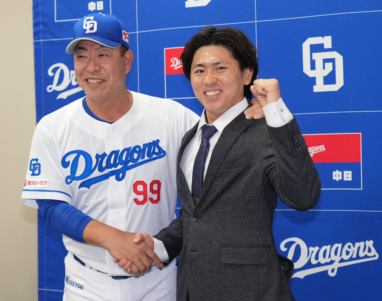 支配下登録が決まり井上監督と握手を交わしポーズを決める三浦（右）（撮影・森本幸一）