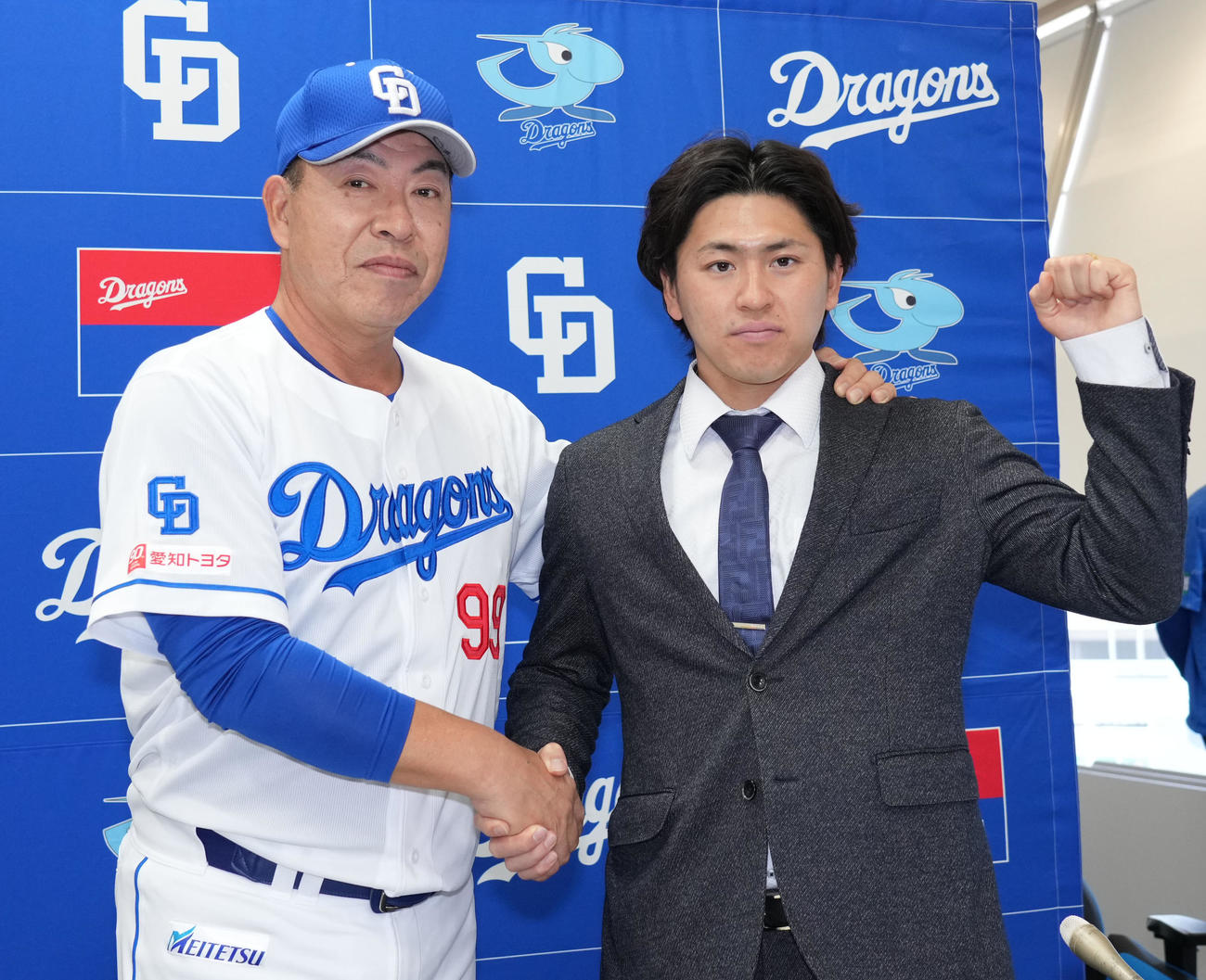 支配下登録が決まり井上監督と握手を交わしポーズを決める三浦（右）（撮影・森本幸一）