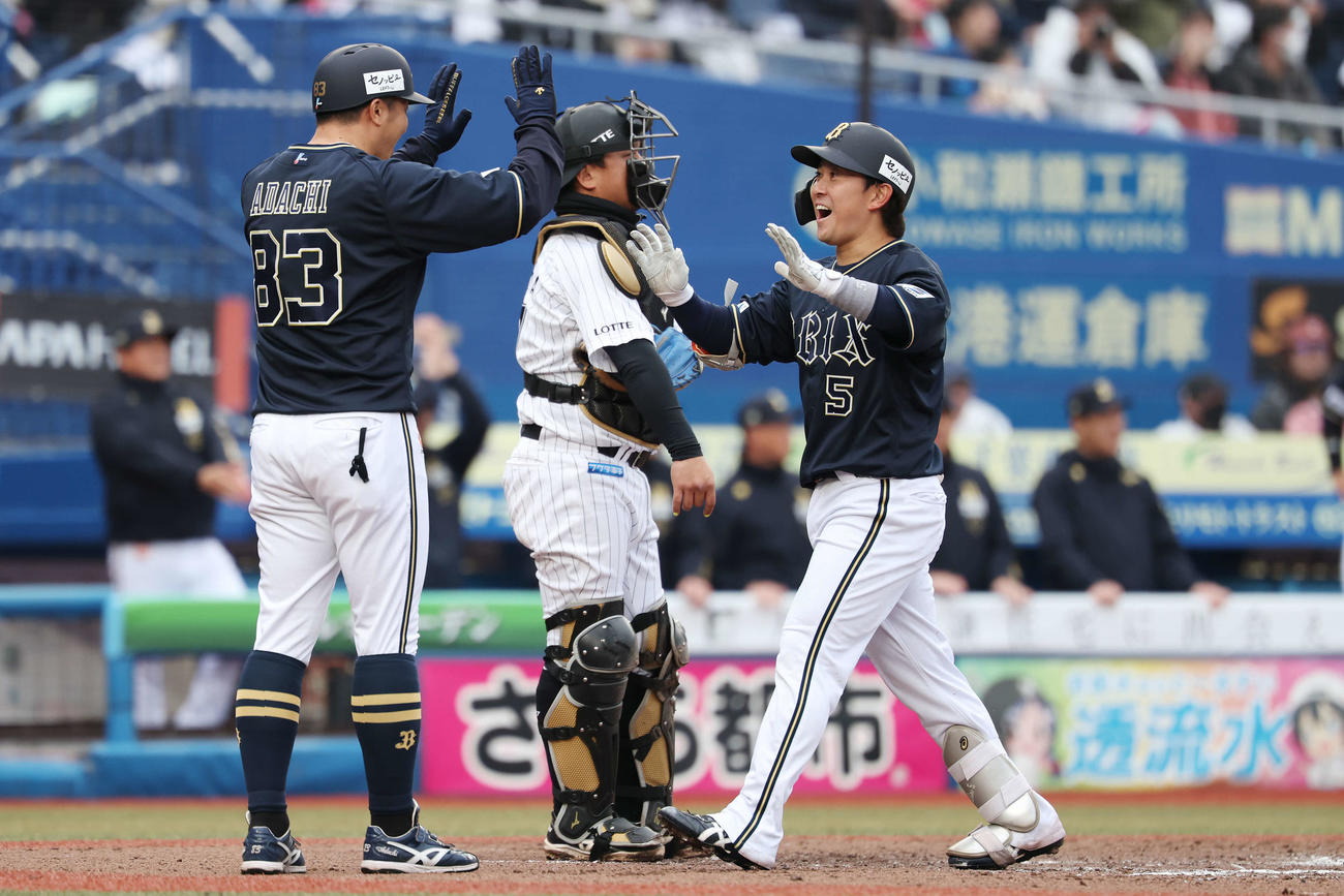 ロッテ対オリックス　7回表オリックス1死一塁、右越え2点本塁打を放ち安達内野守備走塁コーチ（左）とタッチする西野（撮影・宮地輝）