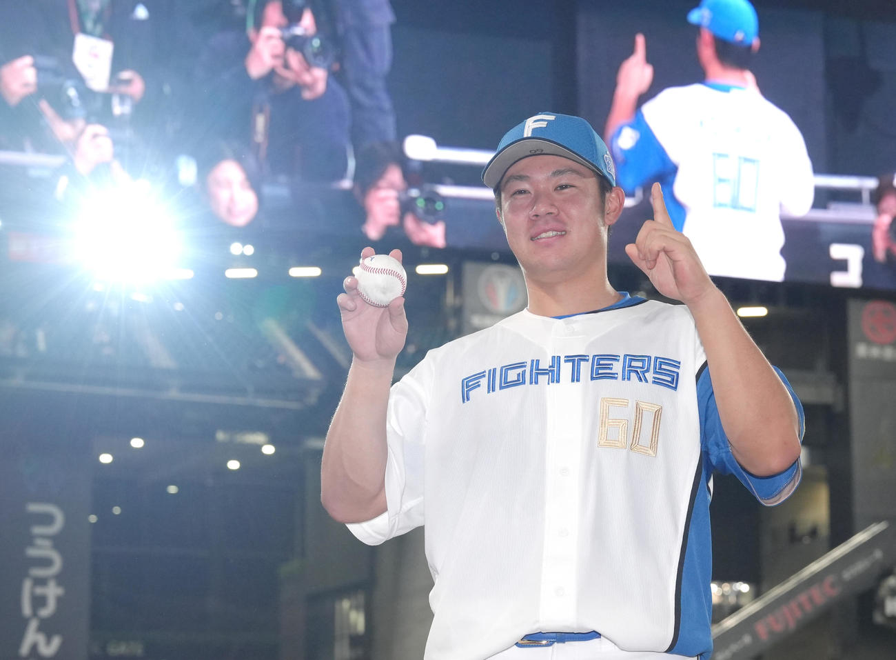 日本ハム対ソフトバンク　プロ初本塁打の記念球を手に笑顔を見せる日本ハム吉田（撮影・足立雅史）