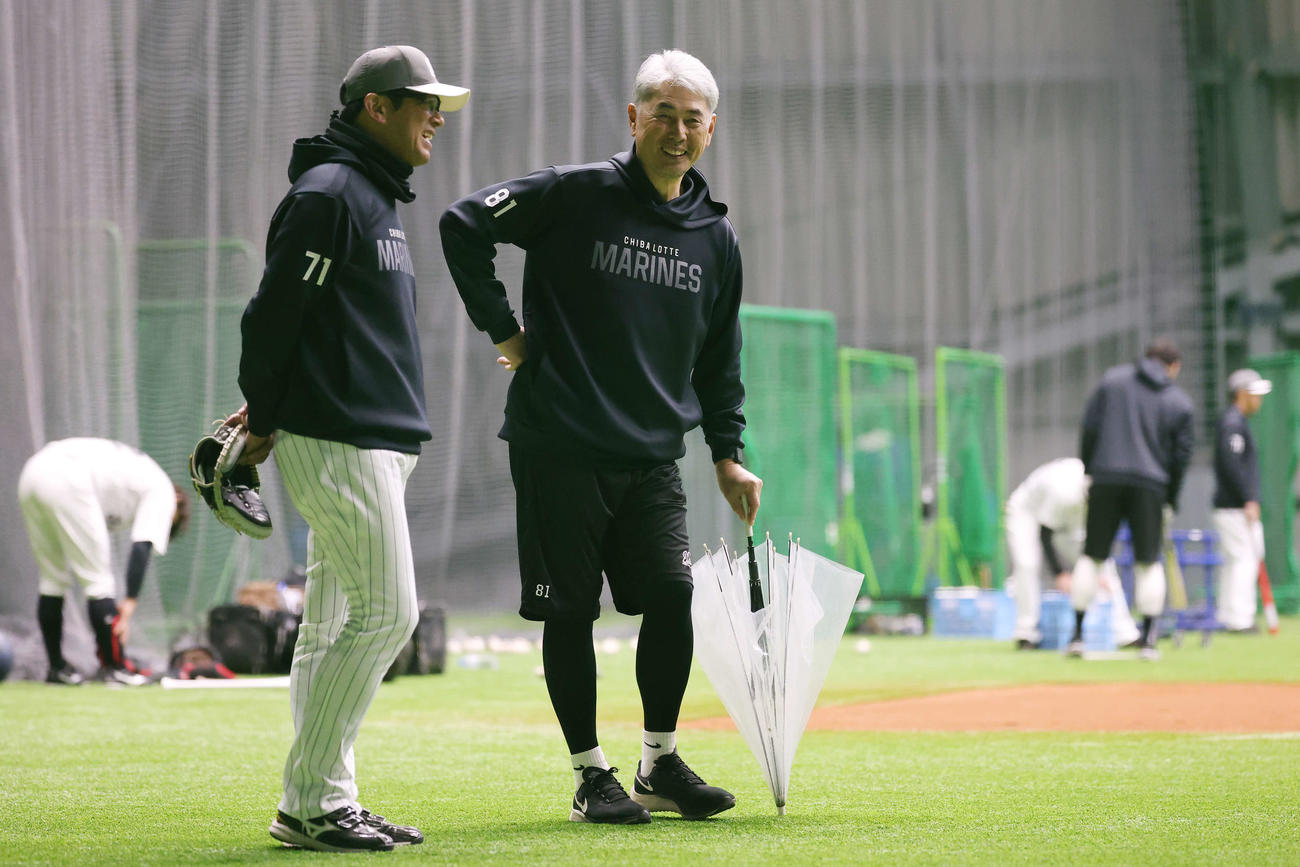 ロッテ対オリックス　試合前、傘を手にロッテ建山投手コーチ（左）と笑顔を見せる吉井監督（撮影・宮地輝）