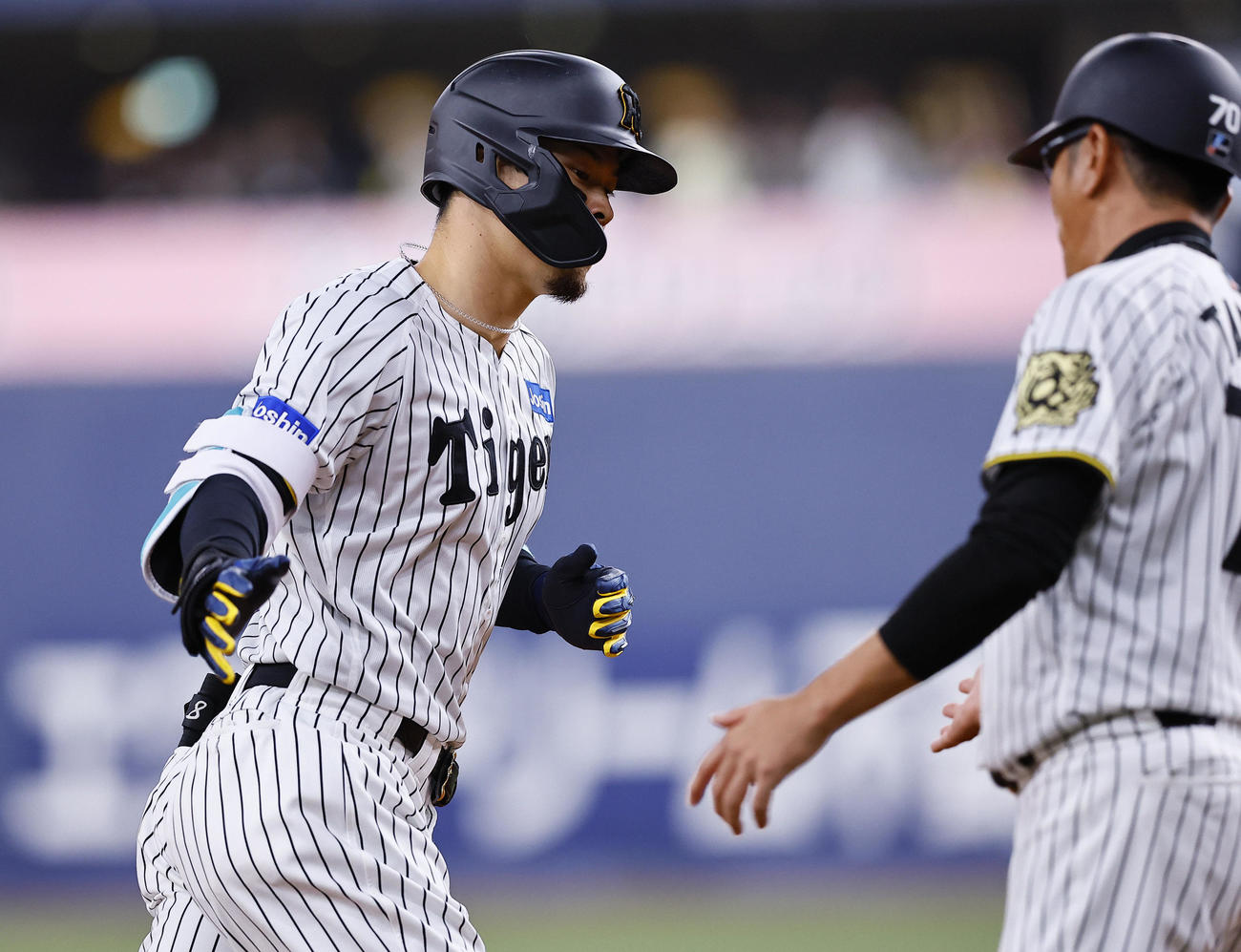 阪神対DeNA 8回裏阪神1死一塁、佐藤輝は左中間に同点の2点本塁打を放ち、三塁コーチとタッチを交わす（撮影・藤尾明華）