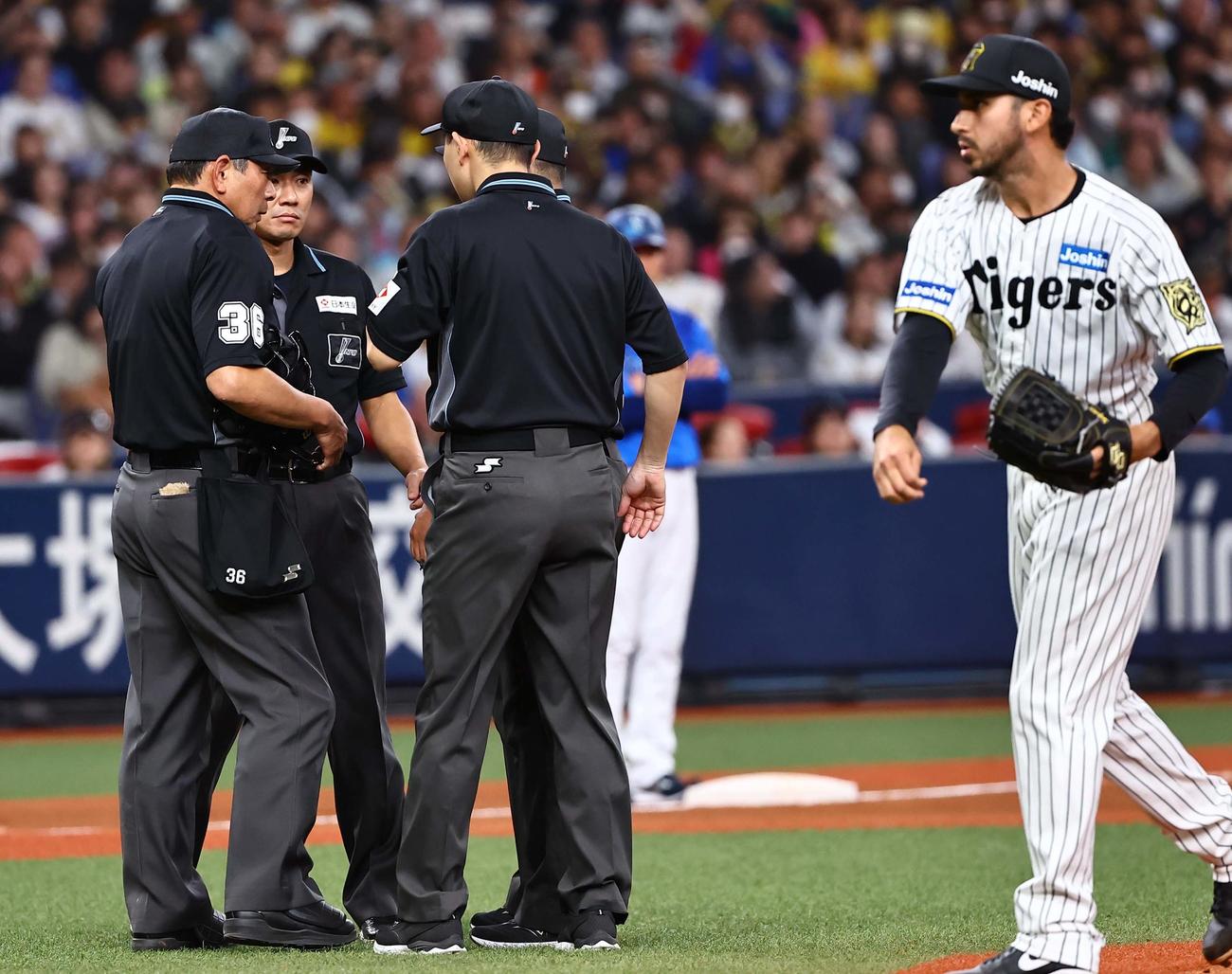 阪神対DeNA 9回表DeNA1死一塁、佐野のファウルの判定を協議する審判団。右はゲラ（撮影・上田博志）