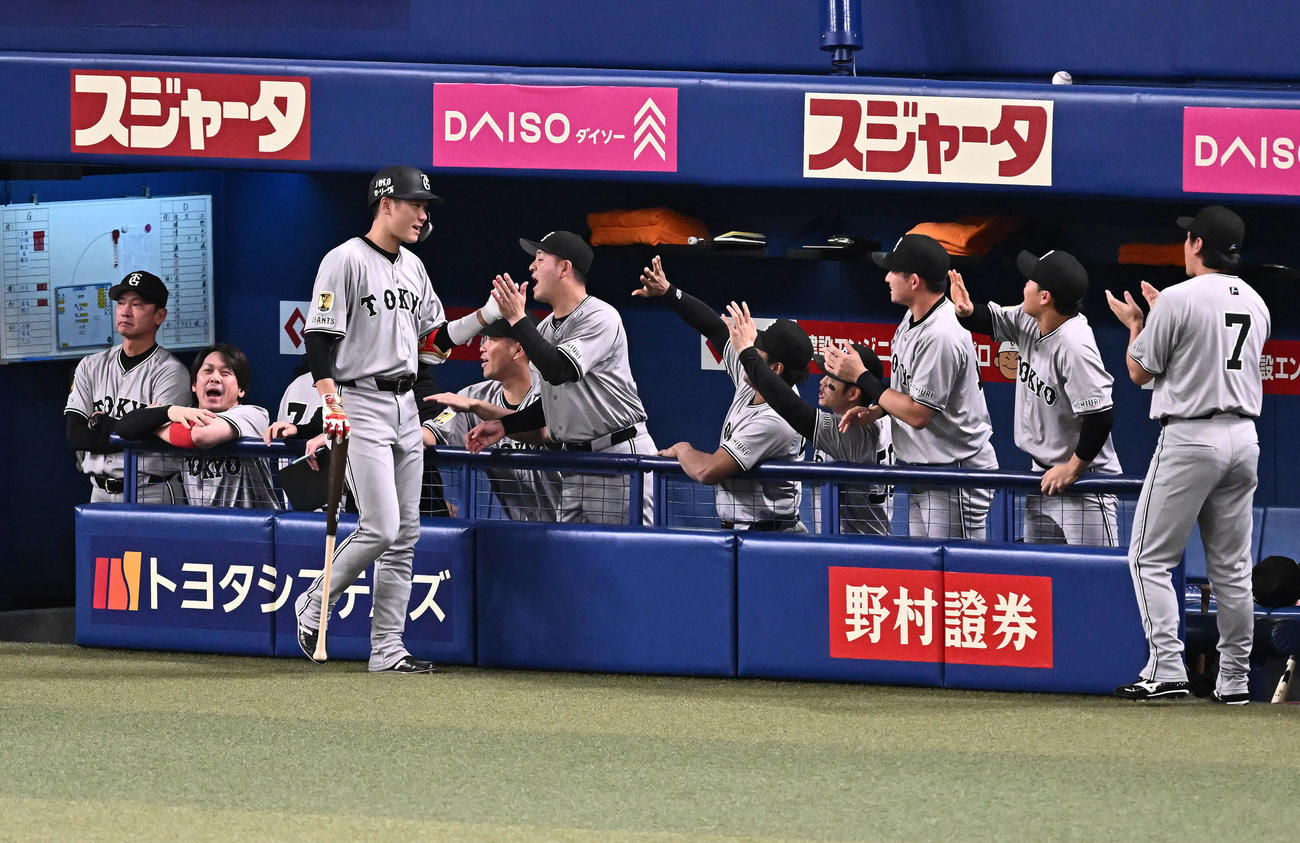 中日対巨人　2回表巨人1死一、三塁、先制の中犠飛を放った坂本勇（手前）はベンチ前でチームメートとタッチをかわす（撮影・滝沢徹郎）