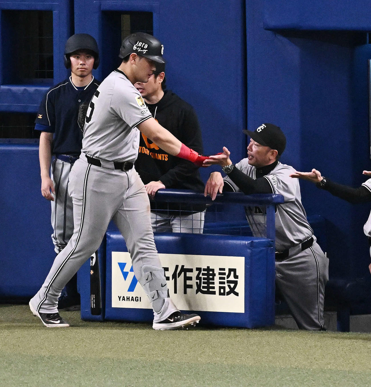 中日対巨人　5回表巨人無死満塁、中犠飛を放った岡本（左）とタッチをかわす阿部監督（撮影・滝沢徹郎）