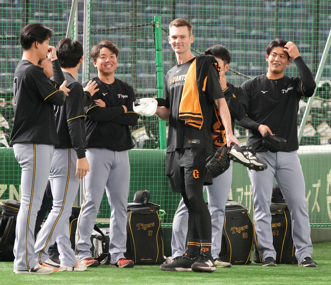 巨人対阪神　先発の村上（左から3人目）ら阪神投手陣と旧交を温める巨人ケラー（撮影・小沢裕）