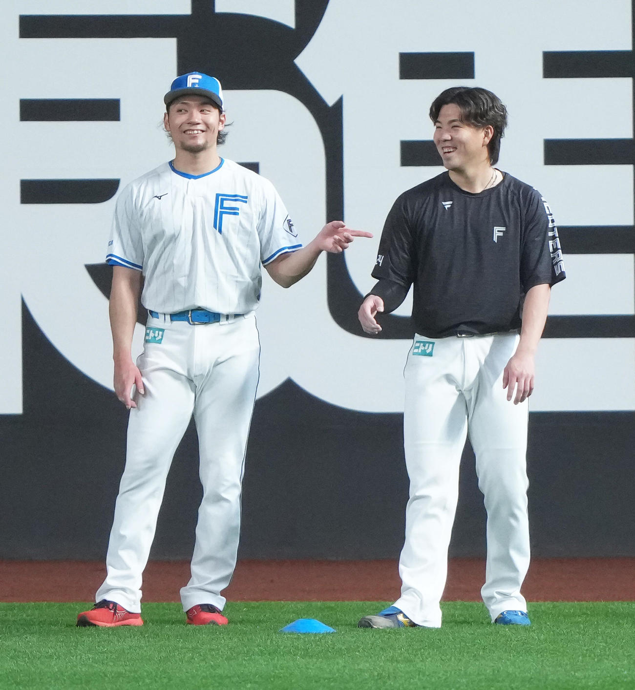 試合前、談笑する日本ハムの伊藤（左）と金村（撮影・足立雅史）