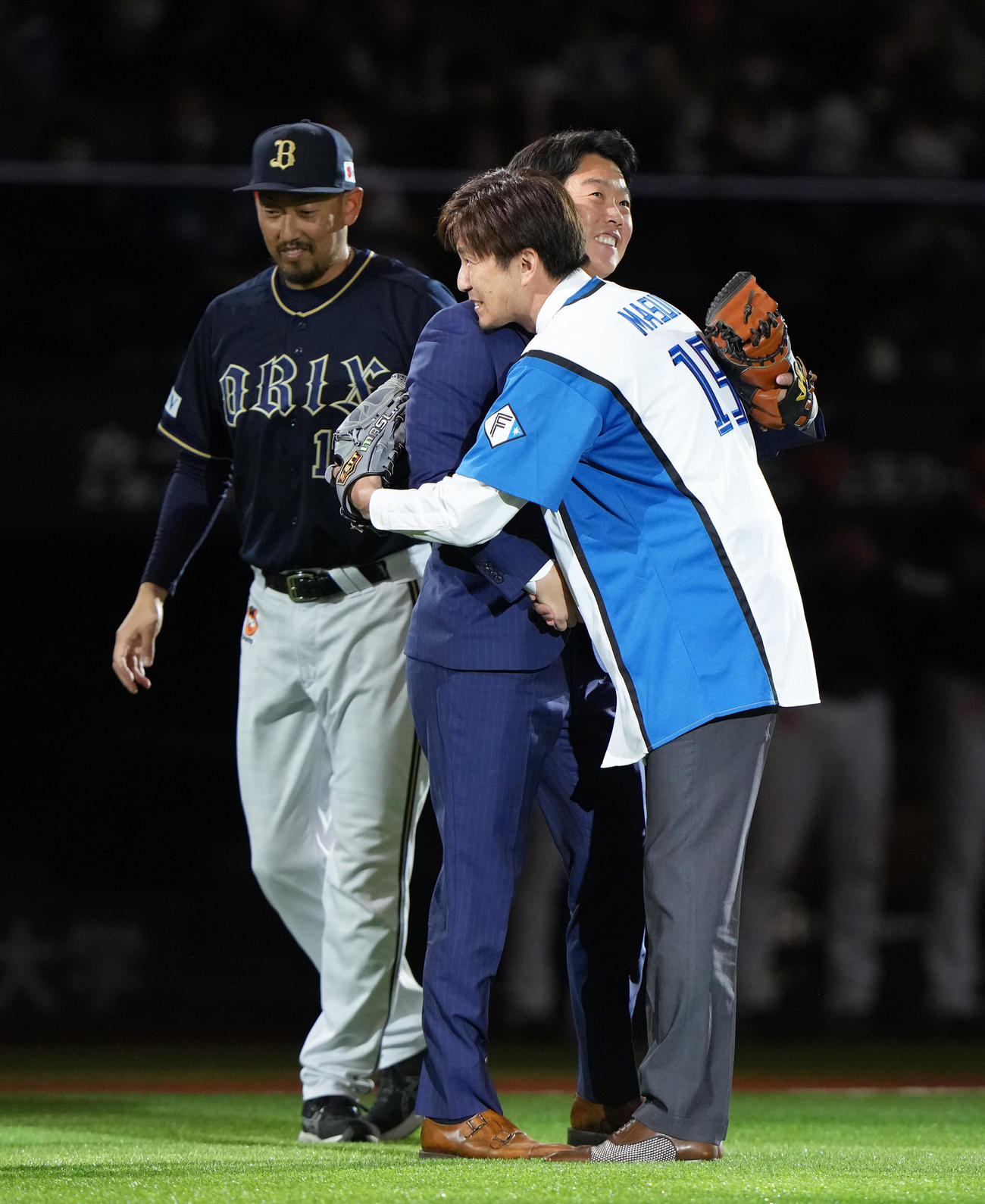 日本ハム対オリックス　ファイナルピッチセレモニーを行った増井氏（右）は鶴岡氏（中央）と抱き合う。左はオリックス平野（撮影・足立雅史）