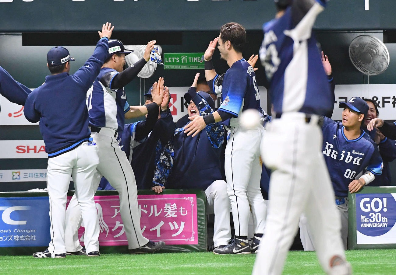 ソフトバンク対西武　4回表西武1死一、二塁、源田の適時右二塁打で生還した野村大（左から2人目）を笑顔で迎える西武ナイン（撮影・岩下翔太）