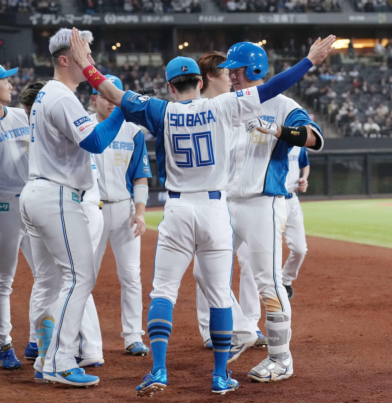 日本ハム対オリックス　6回裏日本ハム2死、吉田（右）は右越え本塁打を放ちタッチで迎えられる（撮影・足立雅史）
