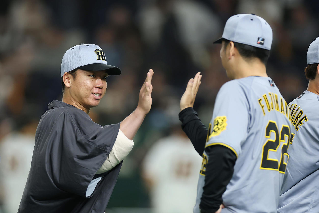 巨人対阪神　巨人に勝利し、阪神藤川監督（右）とタッチを交わす村上（撮影・前田充）