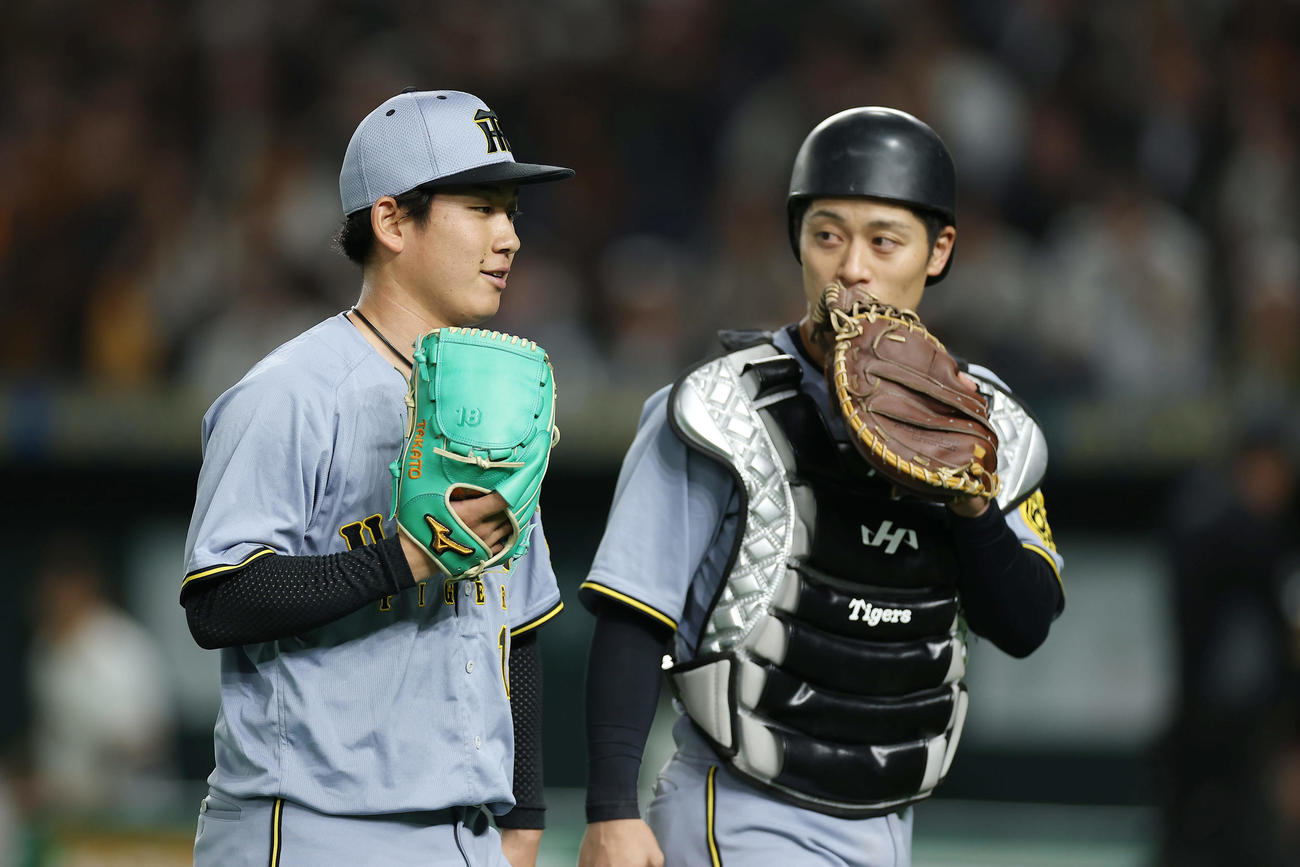 巨人対阪神　8回裏を投げ終え、阪神坂本（右）と言葉を交わしながらベンチへ戻る伊原（撮影・前田充）
