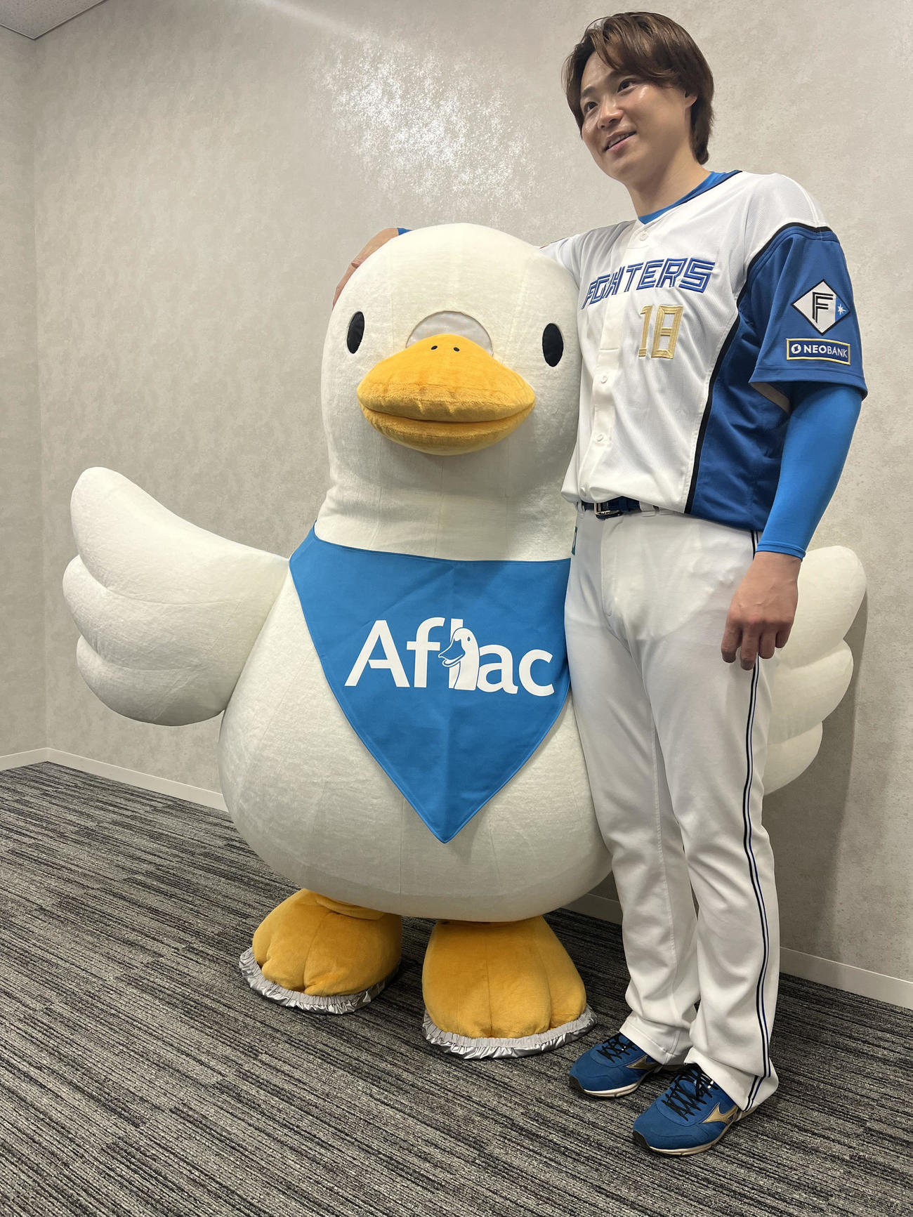 アフラックのマスコットをなでる日本ハム山崎福也（撮影・永野高輔）
