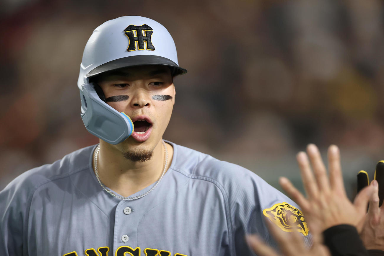 巨人対阪神　8回表阪神1死、この試合2本目となる左越え本塁打を放ち、ナインに迎えられる佐藤輝（撮影・前田充）