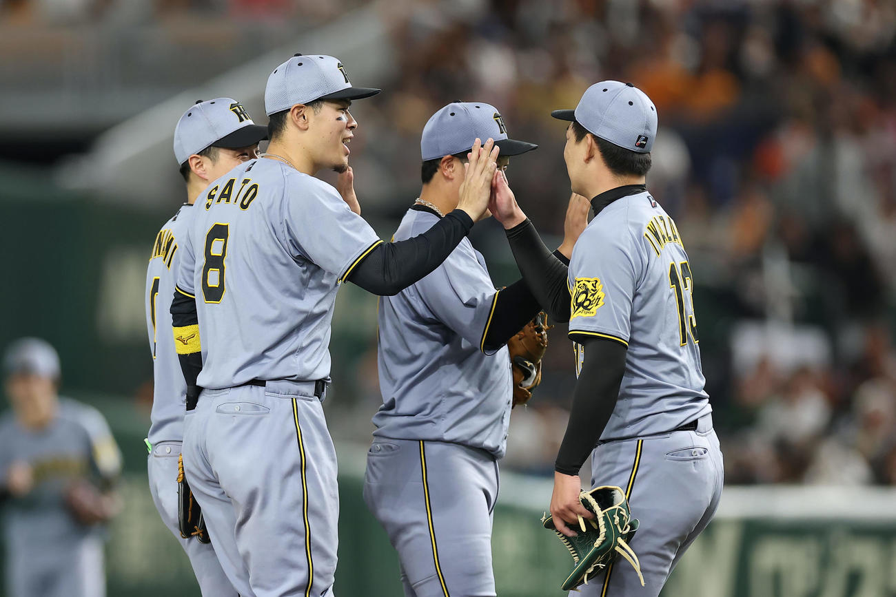 巨人対阪神　巨人に連勝し、タッチを交わして喜ぶ佐藤輝（左から2人目）ら阪神の選手たち（撮影・前田充）
