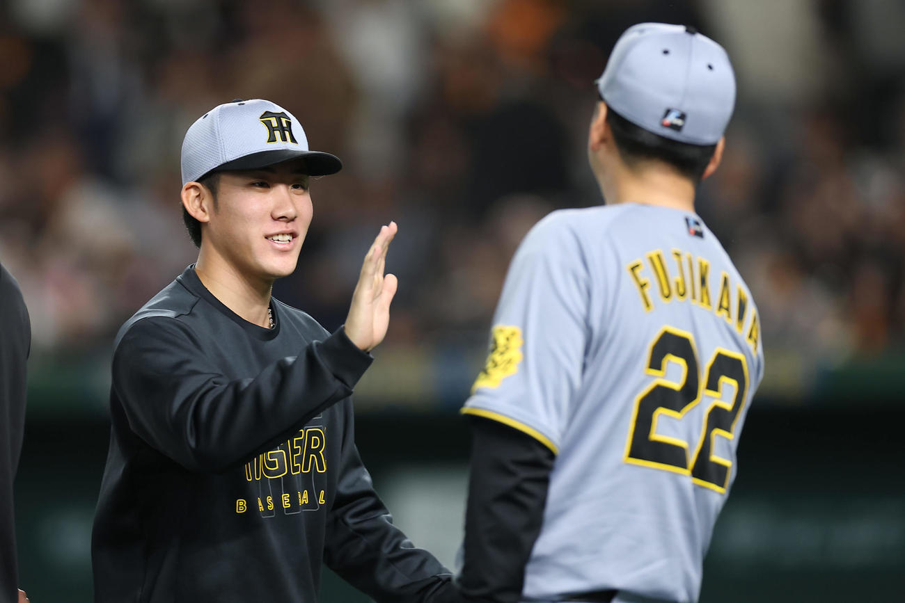 巨人対阪神　巨人に勝利し、阪神藤川監督（右）とタッチを交わす富田（撮影・前田充）