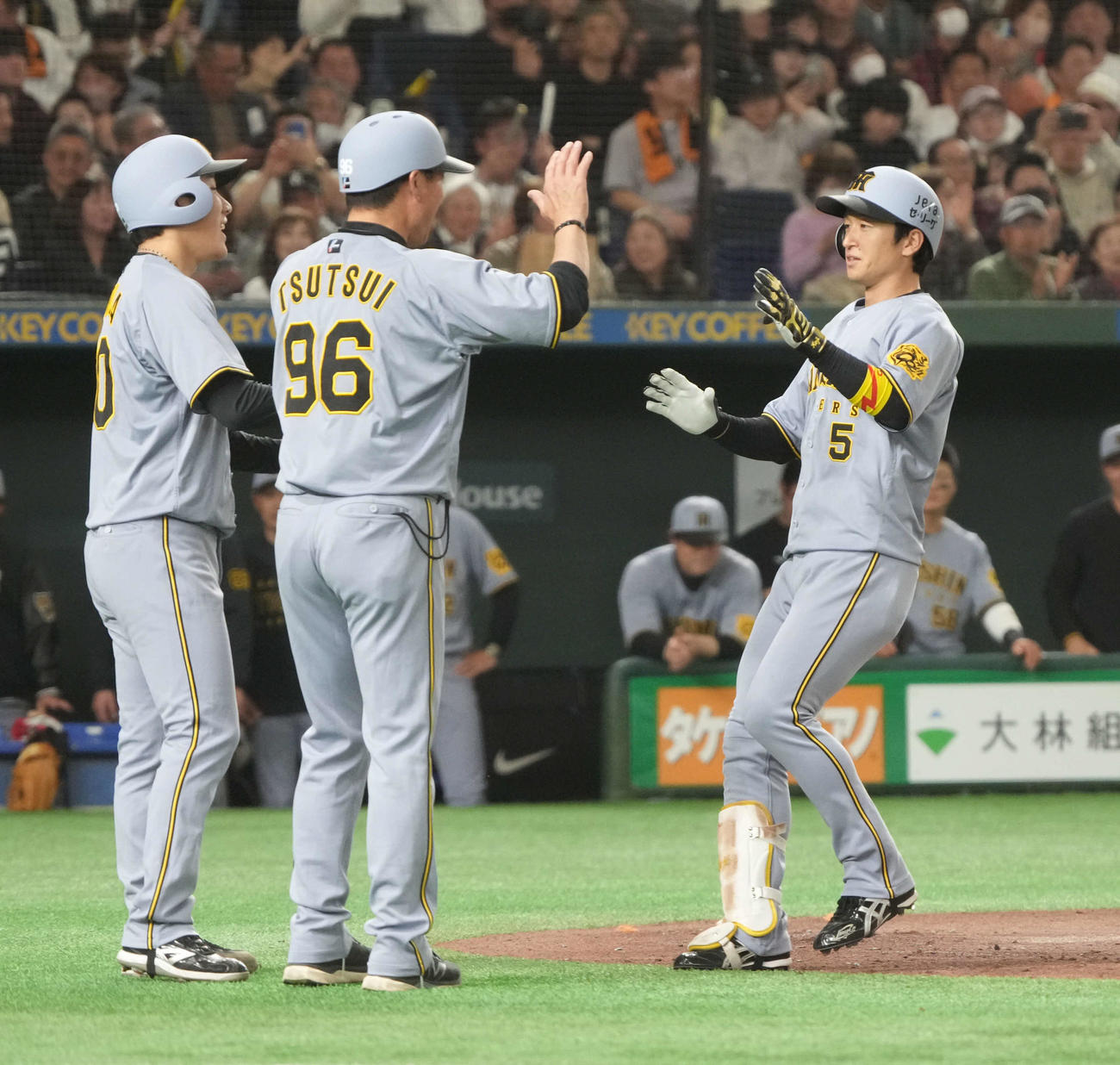 巨人対阪神　3回表阪神1死一塁、近本（左）は右越えに勝ち越し2点本塁打を放ち、左から富田、筒井一塁コーチの祝福を受ける（撮影・小沢裕）