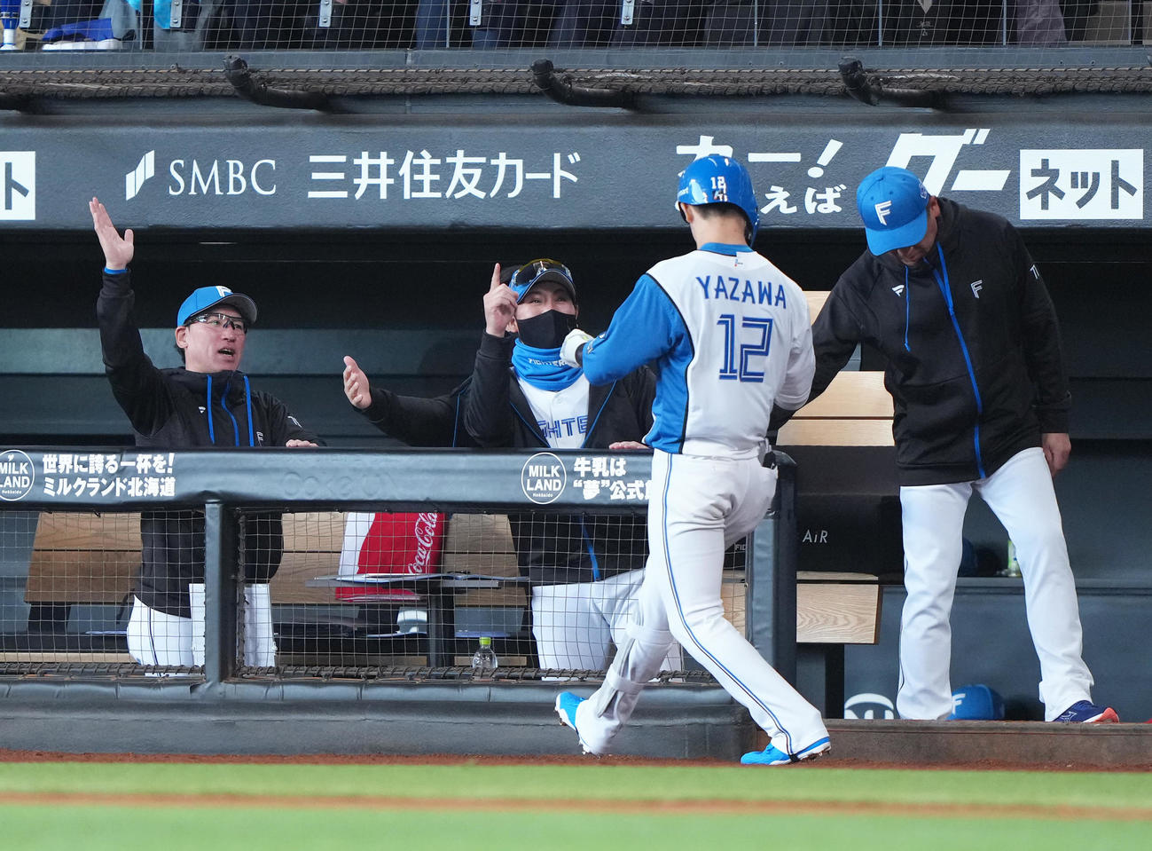 日本ハム対オリックス　1回裏日本ハム1死、矢沢（中央右）は右越え本塁打を放ち新庄監督（中央）らに迎えられる（撮影・足立雅史）