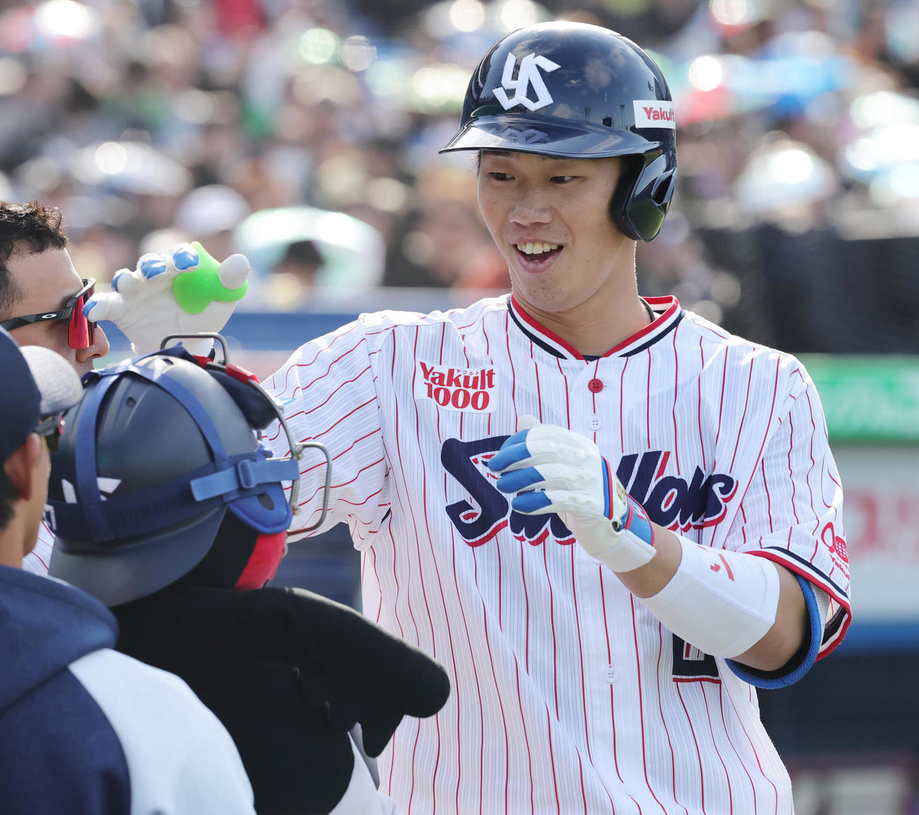 ヤクルト対中日　6回裏ヤクルト1死、左越え本塁打を放ち、キャッチャーマスクをかぶったつば九郎人形らに迎えられる古賀（撮影・野上伸悟）