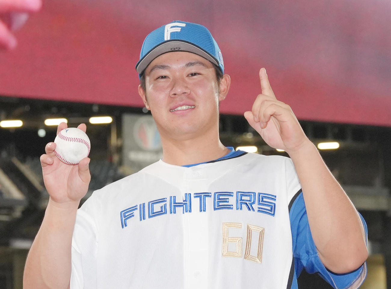 4月2日、プロ初本塁打の記念球を手に笑顔を見せる日本ハム吉田