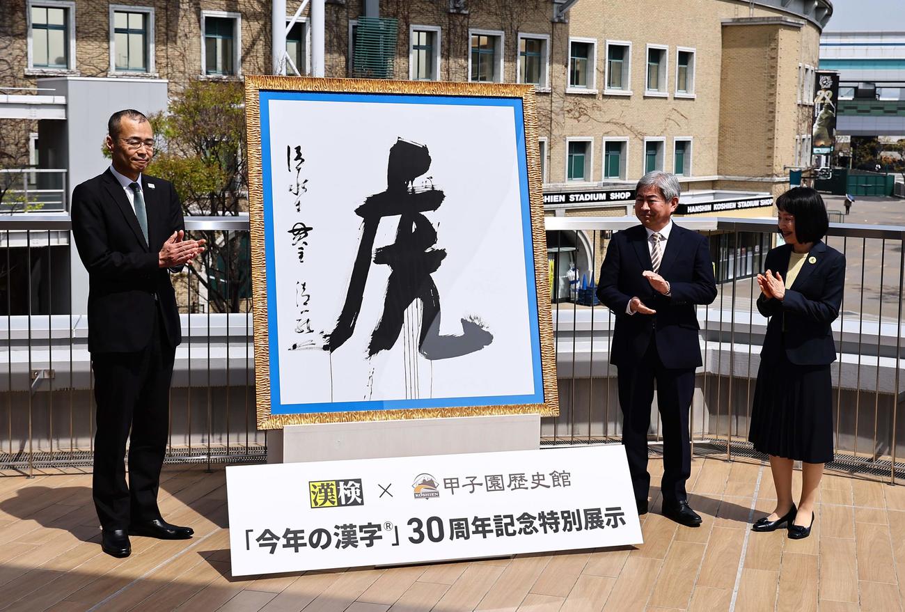 「今年の漢字」30周年を記念して甲子園歴史館に展示されることになった2003年に選ばれた「虎」の大書をお披露目する左から阪神甲子園球場・向井球場長、日本漢字能力検定協会・常任理事の高瀬さん、同・八田さん（撮影・上田博志）
