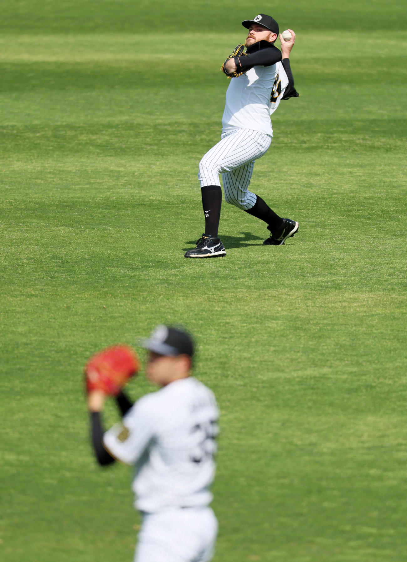 阪神対ヤクルト　練習でキャッチボールするビーズリー。手前は才木（撮影・加藤哉）