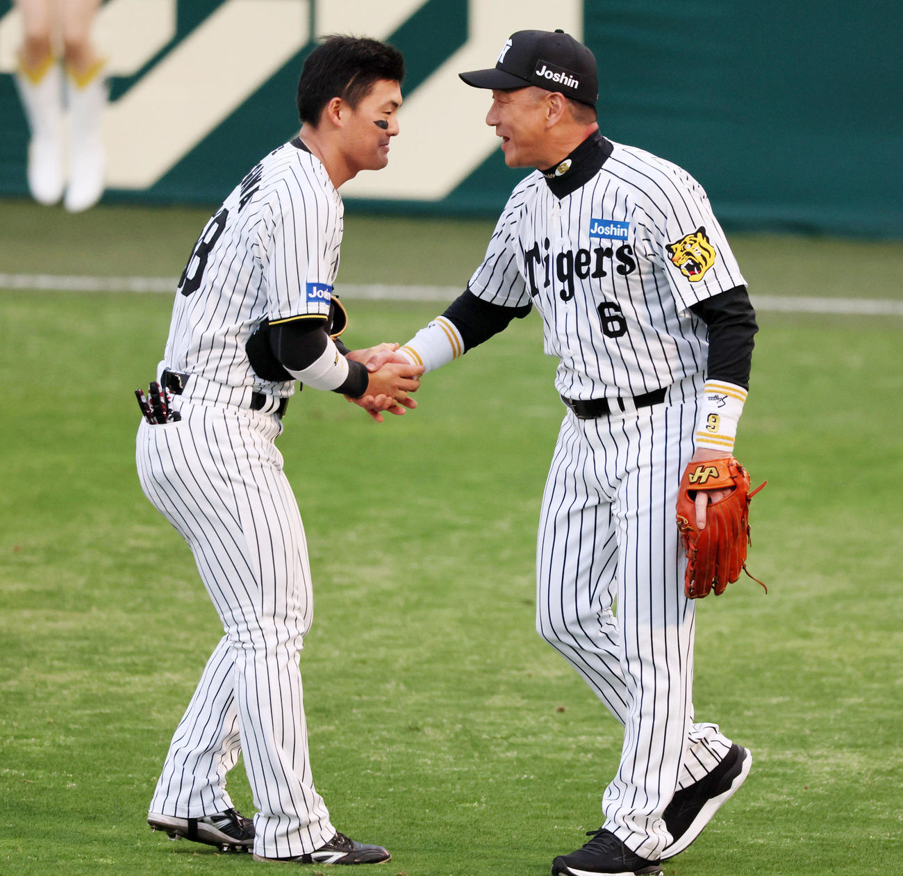 阪神対ヤクルト　試合前、守備位置に就いた阪神レジェンドOBの金本氏（右）と握手する前川（撮影・加藤哉）