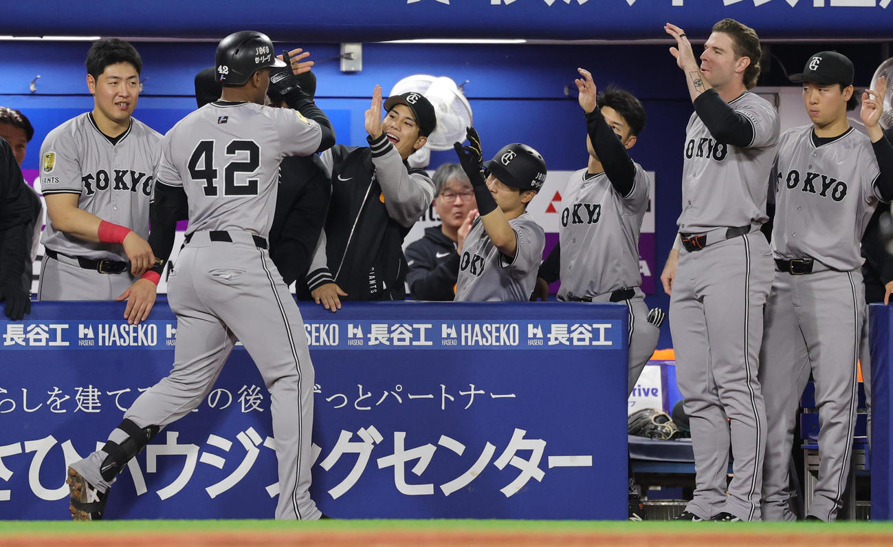 DeNA対巨人　4回表巨人無死、岡本（左端）との2者連続左越え本塁打を放ちベンチに迎えられるヘルナンデス（撮影・野上伸悟）