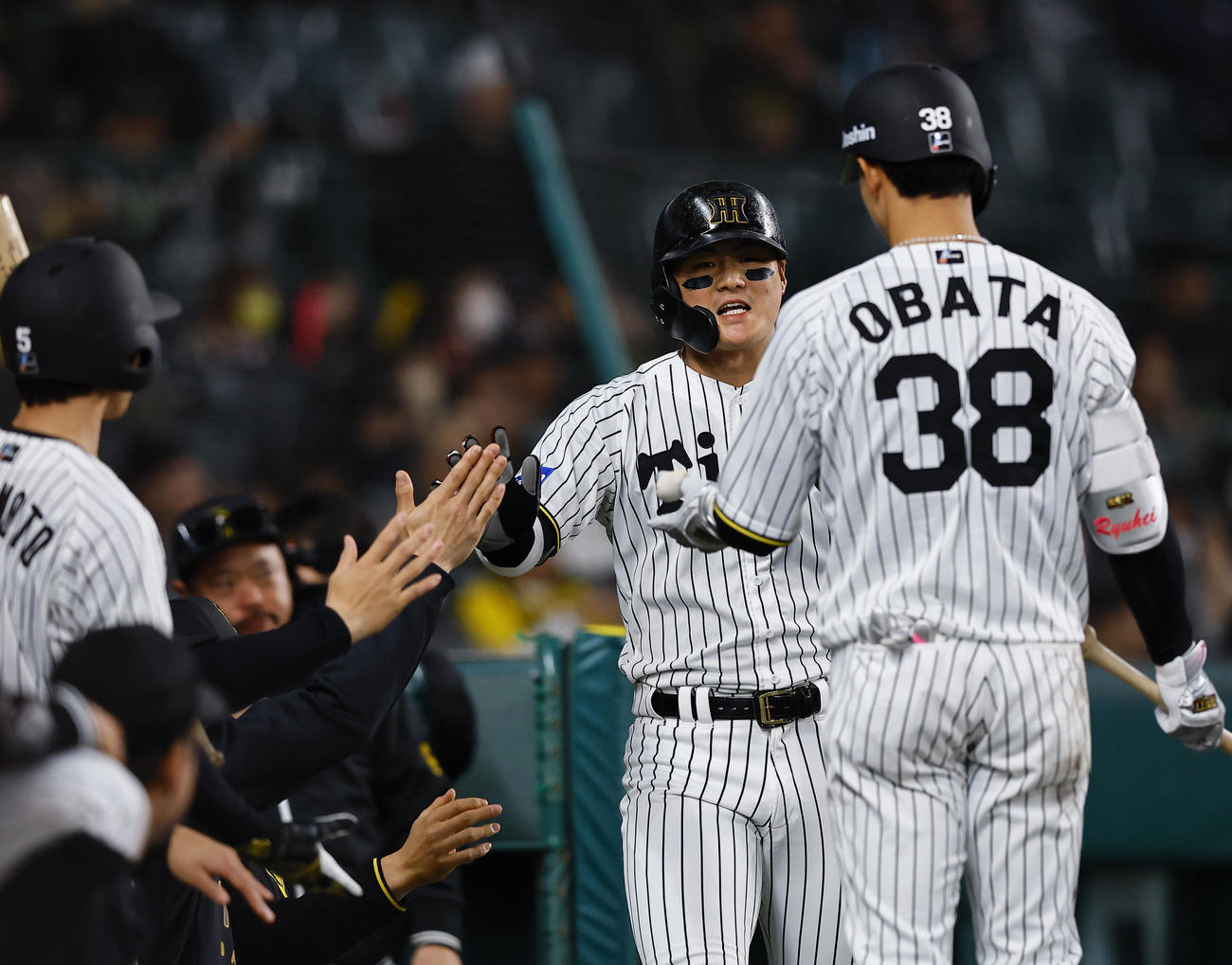 阪神対ヤクルト　2回裏阪神無死満塁、小幡の中犠飛で生還し、タッチを交わす前川（中央）（撮影・藤尾明華）