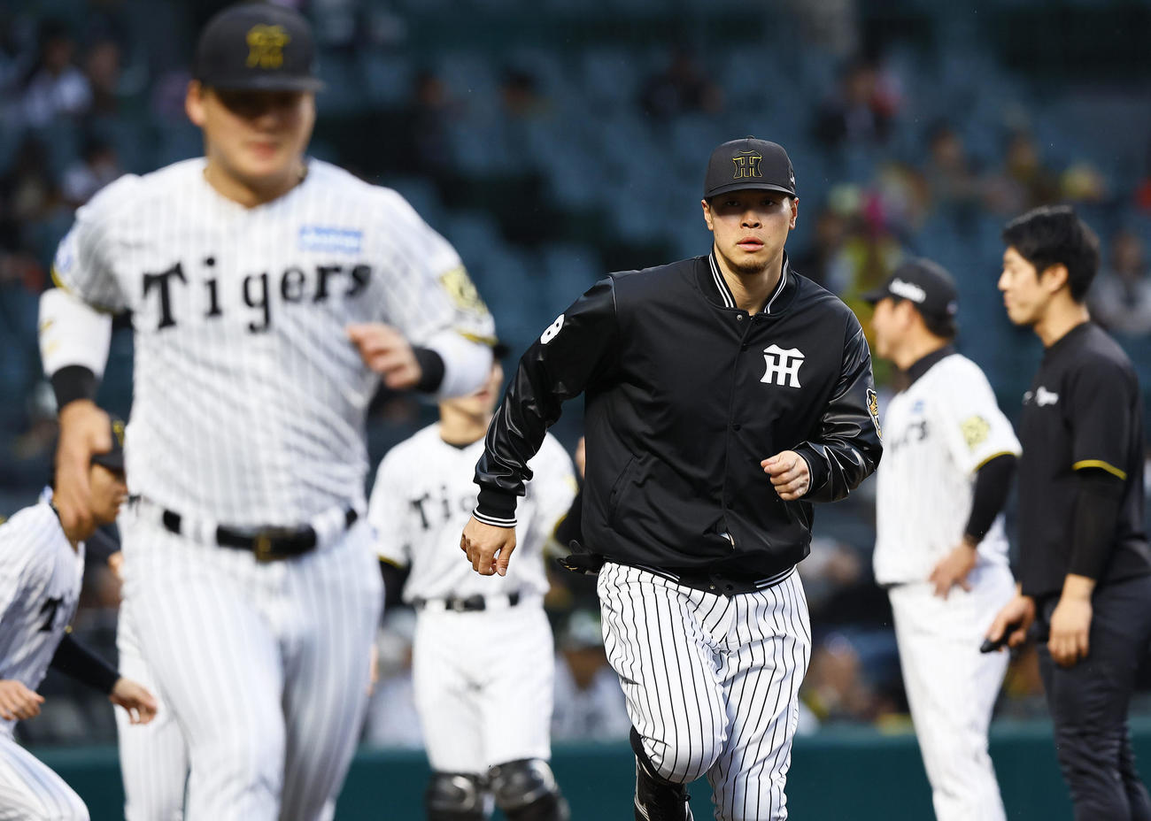 阪神対ヤクルト　試合前ウオーミングアップをする阪神佐藤輝（右）（撮影・藤尾明華）