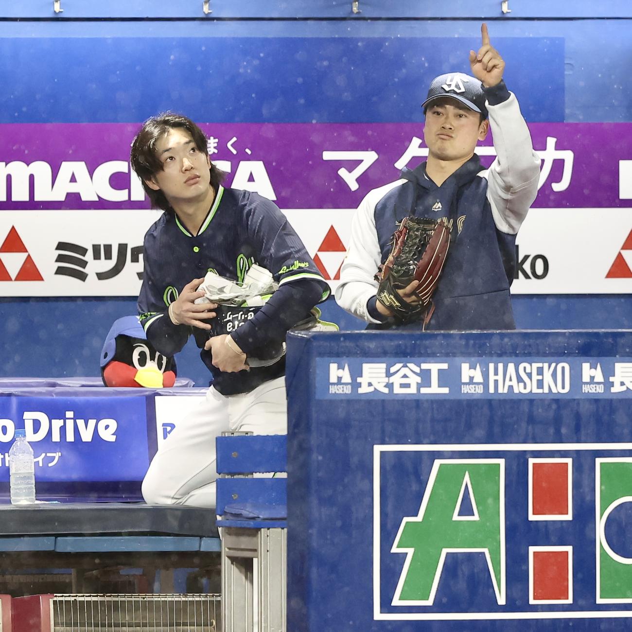 DeNA対ヤクルト　悪天候で試合中止となり、空の様子を伺いなから引き揚げるヤクルト長岡（左）と丸山和（撮影・河田真司）