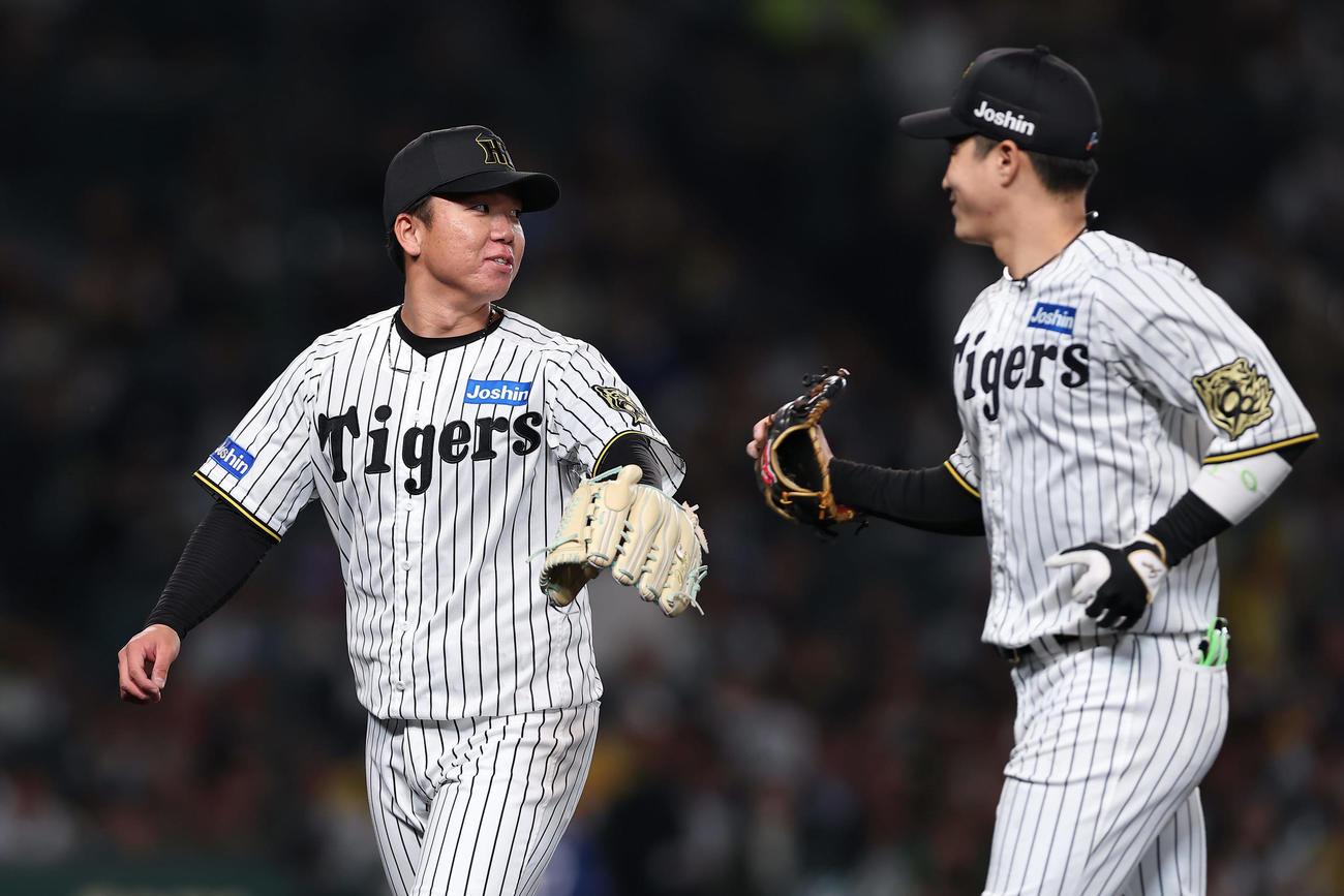 阪神対中日　4回表を投げ終え、笑顔を見せながらベンチへ戻る阪神村上。右は木浪（撮影・前田充）