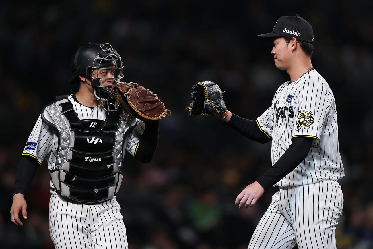 阪神対中日　6回表の中日打線を3者連続三振に仕留め、タッチを交わす阪神坂本（左）と及川（撮影・前田充）