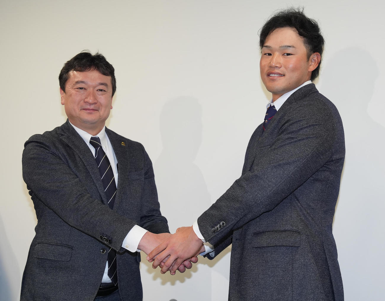 支配下登録となり会見で三笠GM（左）と握手するソフトバンク山本（撮影・鈴木みどり）