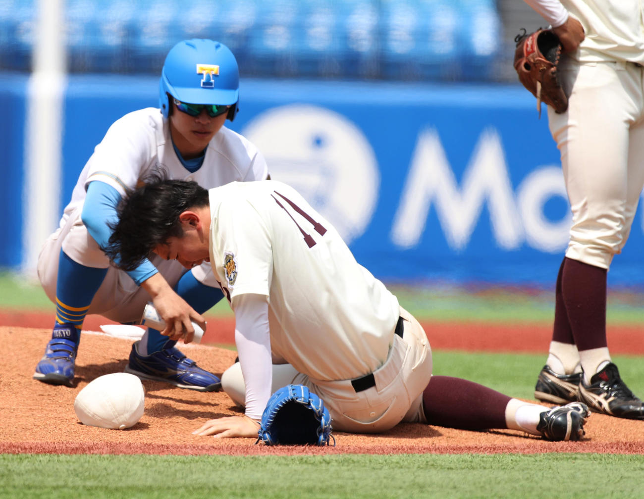 早大対東大　2回表東大無死、秋元の打球を左足に受けた伊藤樹は痛さに倒れる（撮影・柴田隆二）