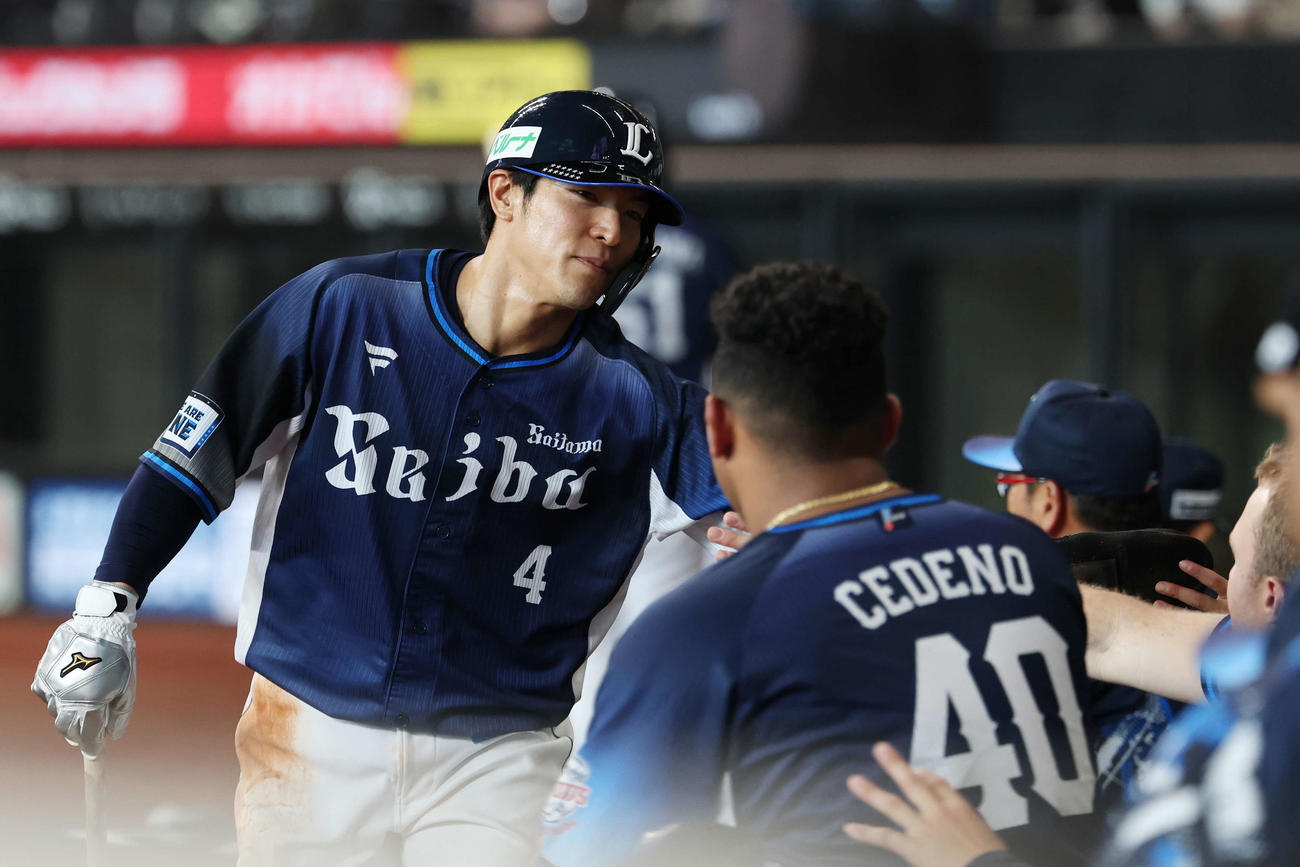 日本ハム対西武　8回表西武2死一、三塁、源田の二塁適時内野安打で生還しタッチを交わす山野辺（撮影・宮地輝）
