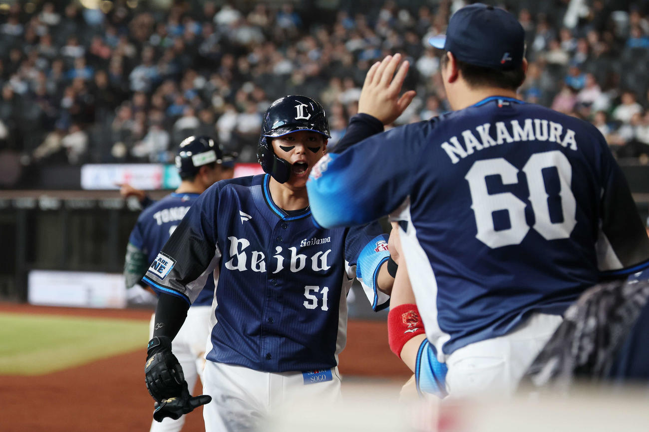 日本ハム対西武　9回表西武無死二塁、平沼の中前適時打で生還しタッチを交わす西川（撮影・宮地輝）