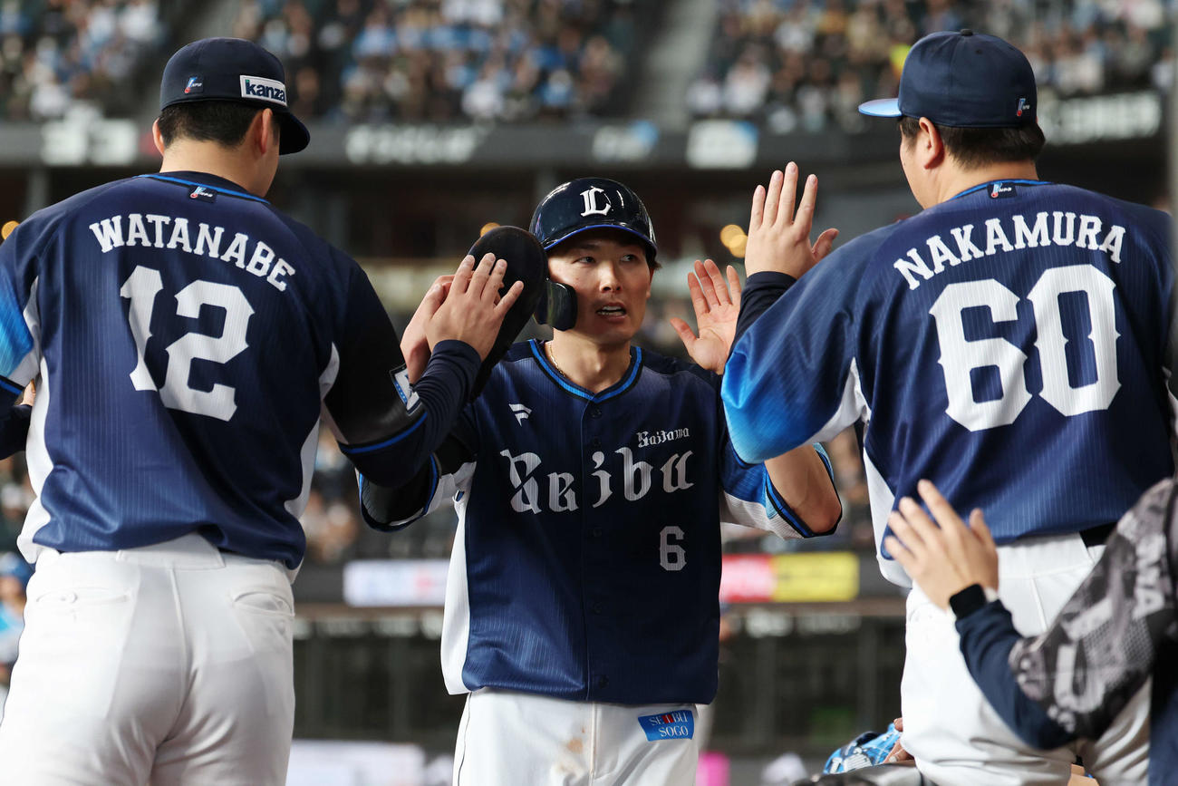 日本ハム対西武　1回表西武2死二塁、セデーニョの先制左前適時打で生還し渡辺（左）と中村剛（右）とタッチする源田（撮影・宮地輝）