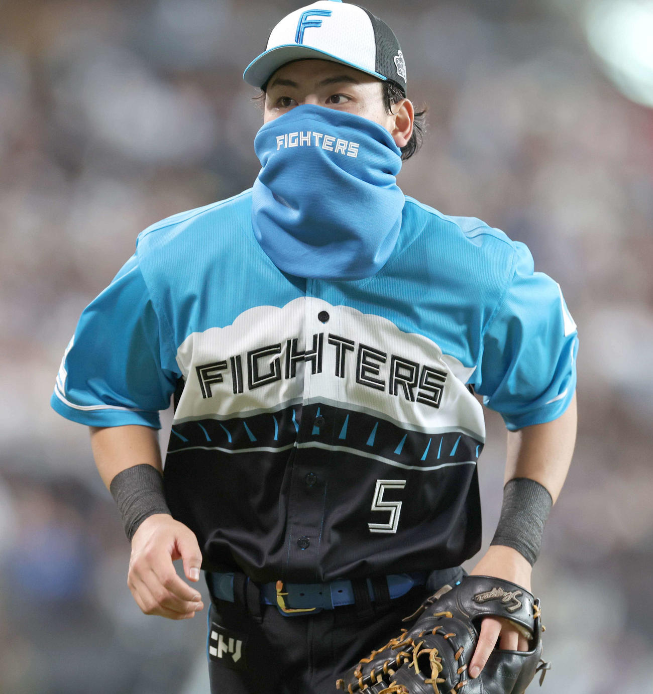 日本ハム対西武　送球が当たり負傷した顔を隠して守備につく野村（撮影・黒川智章）