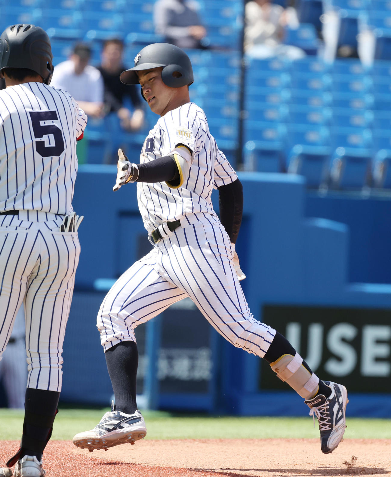 立大対慶大　7回表立大無死、西川は左越えに本塁打を放ち村本とハイタッチする（撮影・柴田隆二）