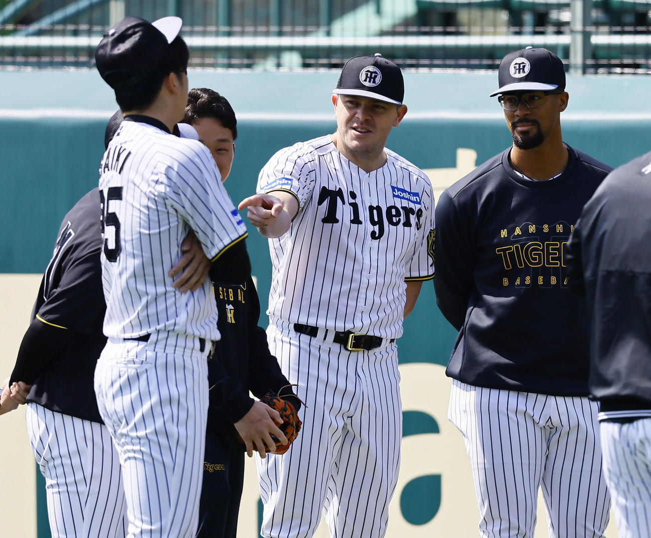 才木浩人（左から2人目）を指さし話しをする阪神ビーズリー（中央）。右はジョン・デュプランティエ