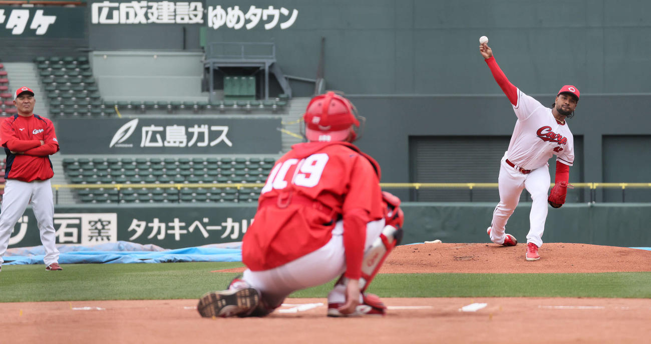菊地原投手コーチ（左）が見守る中、マウンドで投球練習するドミンゲス（撮影・加藤孝規）